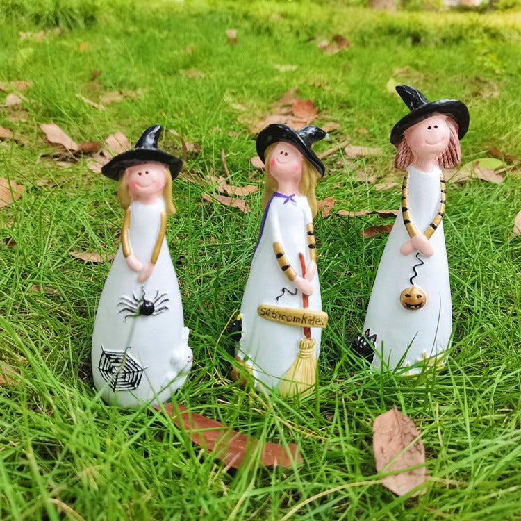 Halloween cute witch figurines styled together in a garden
