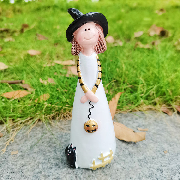 Witch figurine carrying a jack-o-lantern