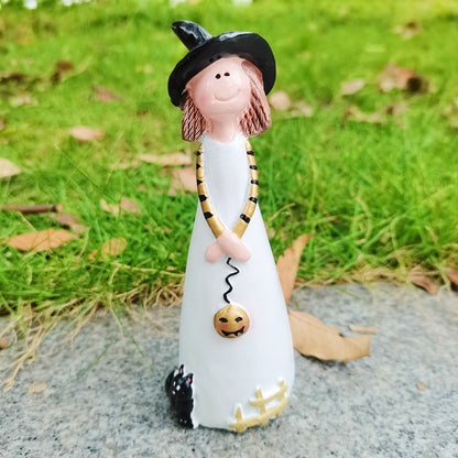 Witch figurine carrying a jack-o-lantern