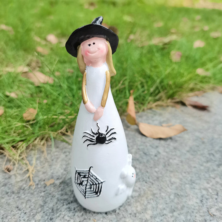 Witch figurine carrying a spider and its web