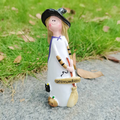 Witch figurine carrying a broom